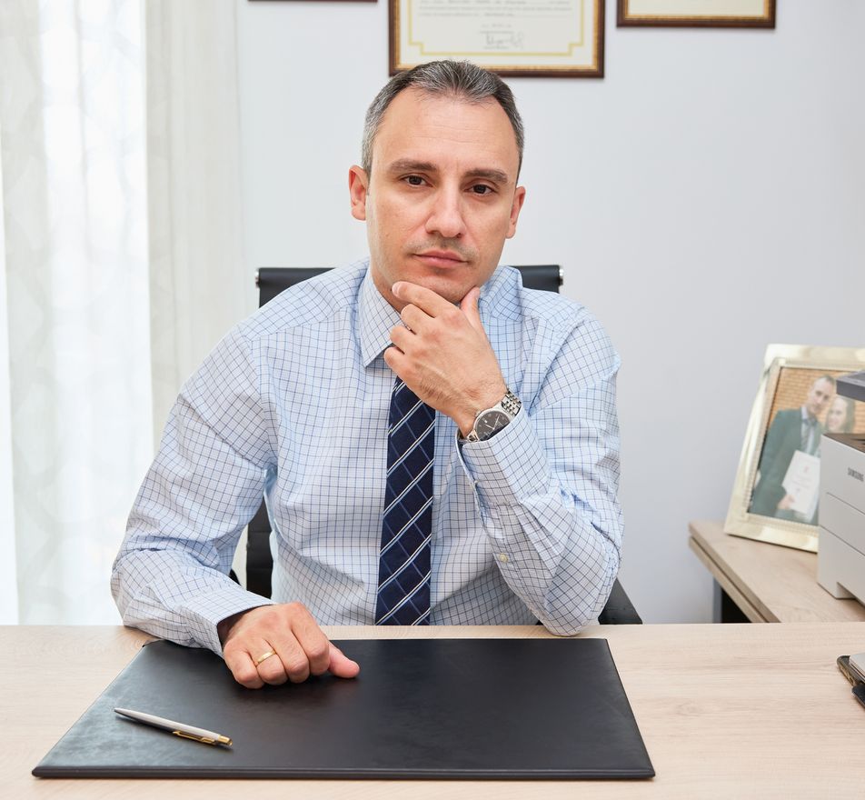 Ο νευρολόγος κάθεται στο γραφείο του με σκεπτικό ύφος, κοιτάζοντας προς την κάμερα.