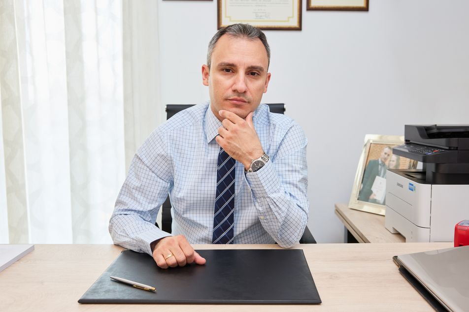 Ο νευρολόγος κάθεται στο γραφείο του με σκεπτικό ύφος, κοιτάζοντας προς την κάμερα.